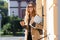 Photo of joyous woman holding laptop while walking through city street