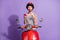 Photo of lady ride scooter direct finger telephone excited face wear helmet striped shirt isolated violet color