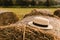 Photo landscape haystack rolls in the field with straw hat. Rustic farming concept. Summer day, sunset