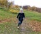 A photo of a laughing carefree little girl running on a path in an autumn park