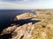 Photo of Lindesnes beacon in summer, South Norway. Aerial shot. Rocky sea coast and blue sky.