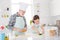 Photo of little girl granddaughter help grandpa in chef cap forming dough funny colorful forms baking cookies together