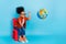 Photo of little girl playing with geography planet globe throwing in away fool around isolated on blue color background