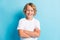 Photo of little kid crossed hands wavy hairdo funny toothy smile wear white shirt isolated blue color background