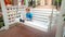 Photo of little toddler boy sitting on white wooden swing bench on old european town street