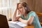 Photo of little upset and bored pupil. Small schoolgirl browsing laptop read homework.