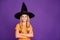 Photo of little witch lady with crossed arms playing paranormal creature halloween party wear orange t-shirt wizard hat