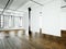 Photo loft expo interior in modern building.Open space studio.Empty white canvas hanging.Wood floor, bricks wall