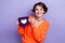 Photo of lovely pretty lady wear orange stylish clothes hold card promote opening new boutique shop isolated on purple