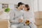 Photo of lovely woman and man going to kiss, husband holds takeaway coffee, sit indoor near cardboard boxes, unpack personal