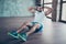 Photo of macho sportsman guy doing static sit ups sitting floor determined person sportswear tank-top shorts sneakers