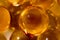 A photo of a magnificent texture of yellow bubbles obtained from spherical capsules of fish oil was taken in macro mode