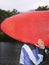 Photo of Man carrying kayak outdoors