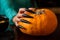 Photo of man`s hands with pumpkin jack , spider sitting at wooden table