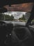 Photo of a man sitting on the seat of a car that is driving on the highway