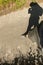 Photo of mans legs and his shadow on a road next to a field