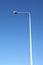 Photo of a metal pole with a lantern on a background of pure blue sky.