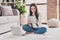 Photo of minded smart lady sit carpet laptop hold tablet finger chin wear eyeglasses white pullover in living room home