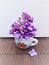 Photo of a miniature vase with a bouquet of lilacs.