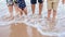 Photo of mother father brother and sister legs in the water on the seaside