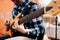 Photo of musician playng on six string fretless bass guitar on the street in front of people.