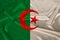 Photo of the national flag of algeria on a luxurious texture of satin, silk with waves, folds and highlights, closeup, copy space