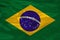 Photo of the national flag of Brazil on a luxurious texture of satin, silk with waves, folds and highlights, close-up, copy space