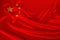 Photo of the national flag of China on a luxurious texture of satin, silk with waves, folds and highlights, closeup, copy space,