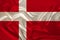 Photo of the national flag of Denmark on a luxurious texture of satin, silk with waves, folds and highlights, close-up, copy space