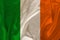 Photo of the national flag of Ireland on a luxurious texture of satin, silk with waves, folds and highlights, closeup, copy space