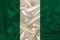 Photo of the national flag of Nigeria on a luxurious texture of satin, silk with waves, folds and highlights, closeup, copy space