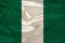 Photo of the national flag of Nigeria on a luxurious texture of satin, silk with waves, folds and highlights, closeup, copy space