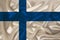Photo of the national flag of the state of Finland on a luxurious texture of satin, silk with waves, folds and highlights, close-