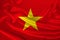 Photo of the national flag of Vietnam on a luxurious texture of satin, silk with waves, folds and highlights, close-up, copy space