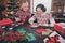 Photo of nice glad cheerful grandparents prepare envelop write letter wear ornament sweater home indoors