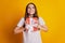 Photo of nice glad emotional lady hold giftbox look up empty space wear white t-shirt posing on yellow background