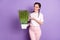 Photo o nice pretty young woman display hand pot grass smile good mood isolated on violet color background