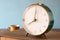 Photo of old alarm clock over wooden table, with faded retro effect