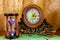 Photo of an old clock and sandglass on brown background