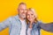 Photo of old couple wife husband make selfie good mood smile enjoy cool isolated on yellow color background
