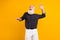Photo of old happy positive cheerful man look empty space dance enjoy good mood isolated on yellow color background