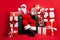 Photo of old man sit armchair indicate finger computer wear x-mas costume isolated decorated red color background