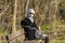 Photo of an older woman with a protective FFP2 or FFP3 N95 or N99 mask with a filter sitting in a park enjoying the warm day