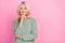 Photo of optimistic elder blond lady hand face look advert wear grey pullover isolated over pink color background