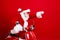Photo of optimistic grandfather wear santa costume glasses riding on moped raising fist look empty space isolated on red