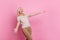 Photo of overjoyed person with stylish hair dressed striped t-shirt catching object look empty space isolated on pink