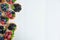 Photo pattern with tartlets on a white wooden background. Cakes with berries of marina, blueberry, blueberry with mint