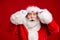 Photo of pensioner old man grey beard excited look hold eyeglasses open mouth shock see female same outfit wear santa