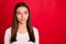 Photo of pensive interested girl hearing people pronouncing her name away from her while isolated with red background