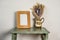 photo picture frame mock up with retro antique pouring jug with dried flowers on a green timber table plain